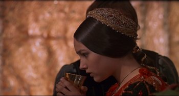 Movie still from “Romeo and Juliet” (1968), directed by Franco Zeffirelli – A young woman holding a cup of coffee; Close Up shot, Over the shoulder angle
