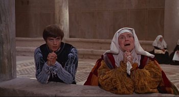 Movie still from “Romeo and Juliet” (1968), directed by Franco Zeffirelli – Two people sitting next to each other on a stage; Medium shot, High angle