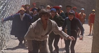 Movie still from “Romeo and Juliet” (1968), directed by Franco Zeffirelli – A group of young men in a crowd of people; Wide shot, High angle