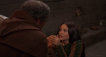 Movie still from “Romeo and Juliet” (1968), directed by Franco Zeffirelli – A young woman is looking at an older man in front of a brick wall; Medium shot, High angle