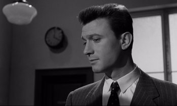Movie still from “Room at the Top” (1958), directed by Jack Clayton – Black and white photograph of a man wearing a suit and tie; Close Up shot, Low angle