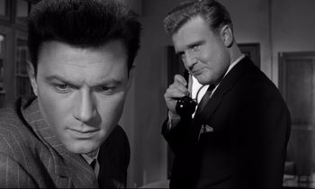 Movie still from “Room at the Top” (1958), directed by Jack Clayton – A man talking on a phone next to another man; Close Up shot, Low angle