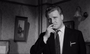 Movie still from “Room at the Top” (1958), directed by Jack Clayton – A black and white photo of a man smoking a cigarette; Close Up shot, Low angle