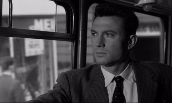 Movie still from “Room at the Top” (1958), directed by Jack Clayton – A black and white photo of a man in a suit and tie; Close Up shot, Low angle