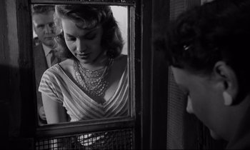 Movie still from “Room at the Top” (1958), directed by Jack Clayton – A black and white photo of a woman looking at her reflection in a mirror; Close Up shot, Over the shoulder angle