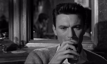 Movie still from “Room at the Top” (1958), directed by Jack Clayton – A black and white photo of a man drinking a glass of wine; Close Up shot, Over the shoulder angle
