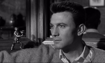 Movie still from “Room at the Top” (1958), directed by Jack Clayton – Black and white photograph of a young man looking into the distance; Close Up shot, Low angle