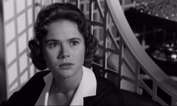 Movie still from “Room at the Top” (1958), directed by Jack Clayton – Black and white photograph of a young woman in front of a staircase; Close Up shot, Low angle
