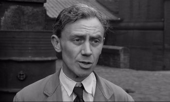 Movie still from “Room at the Top” (1958), directed by Jack Clayton – An older man wearing a suit and a tie; Close Up shot, High angle