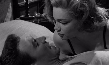 Movie still from “Room at the Top” (1958), directed by Jack Clayton – A man and a woman kissing on a bed; Close Up shot, High angle