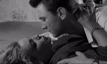 Movie still from “Room at the Top” (1958), directed by Jack Clayton – A man and a woman are kissing in a room; Close Up shot, Low angle