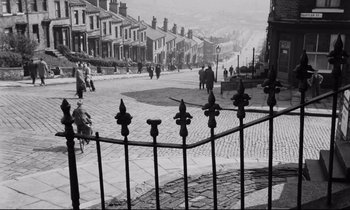 Movie still from “Room at the Top” (1958), directed by Jack Clayton – A black and white photo of people walking down a street; Extreme Wide shot, High angle