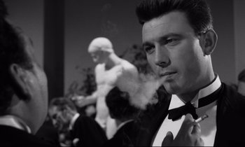 Movie still from “Room at the Top” (1958), directed by Jack Clayton – A black and white photo of a man smoking a cigarette; Close Up shot, Low angle