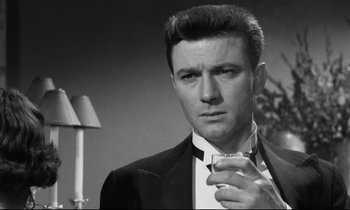 Movie still from “Room at the Top” (1958), directed by Jack Clayton – A black and white photo of a man in a suit and tie; Close Up shot, Low angle