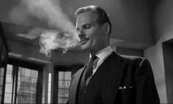 Movie still from “Room at the Top” (1958), directed by Jack Clayton – A black and white photo of a man smoking a cigarette; Close Up shot, Low angle