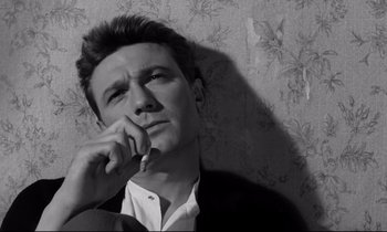 Movie still from “Room at the Top” (1958), directed by Jack Clayton – Black and white photograph of a man leaning up against a wall; Close Up shot, Low angle