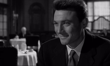 Movie still from “Room at the Top” (1958), directed by Jack Clayton – Black and white photograph of a man in a suit; Close Up shot, Over the shoulder angle