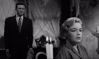 Movie still from “Room at the Top” (1958), directed by Jack Clayton – A man and a woman standing next to each other in front of a window; Medium shot, Low angle