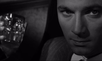 Movie still from “Room at the Top” (1958), directed by Jack Clayton – A man in a suit and tie; Extreme Close Up shot, Low angle