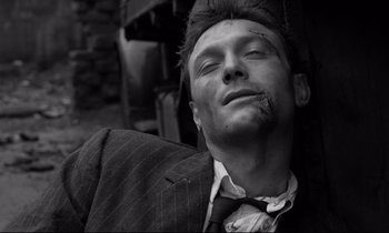 Movie still from “Room at the Top” (1958), directed by Jack Clayton – Black and white photograph of a man in a business suit; Close Up shot, High angle