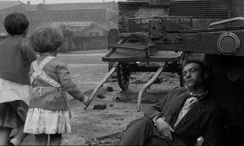 Movie still from “Room at the Top” (1958), directed by Jack Clayton – An old photo of a man and a little girl; Wide shot, High angle