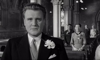 Movie still from “Room at the Top” (1958), directed by Jack Clayton – A black and white photo of a man and two women; Close Up shot, Low angle