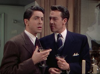 Movie still from “Rope” (1948), directed by Alfred Hitchcock – A couple of men standing next to each other holding wine glasses; Medium shot, Over the shoulder angle