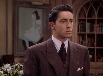 Movie still from “Rope” (1948), directed by Alfred Hitchcock – A man wearing a suit and tie in a room; Medium shot, Over the shoulder angle