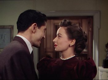 Movie still from “Rope” (1948), directed by Alfred Hitchcock – A man and a woman standing next to each other; Medium shot, High angle