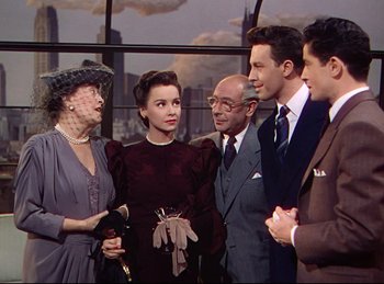 Movie still from “Rope” (1948), directed by Alfred Hitchcock – A group of men and women standing next to each other in front of a window; Medium shot, Over the shoulder angle