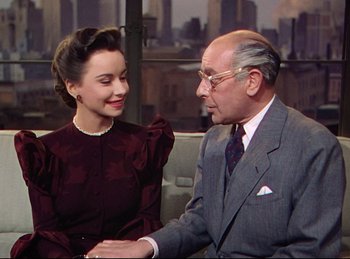 Movie still from “Rope” (1948), directed by Alfred Hitchcock – An older man and a young woman are holding hands; Medium shot, Over the shoulder angle