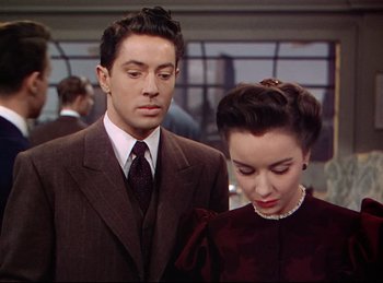 Movie still from “Rope” (1948), directed by Alfred Hitchcock – A man and a woman standing next to each other; Medium shot, High angle