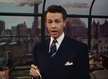 Movie still from “Rope” (1948), directed by Alfred Hitchcock – A man in a suit and tie standing in front of a window; Medium shot, Low angle