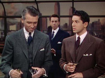 Movie still from “Rope” (1948), directed by Alfred Hitchcock – A group of men standing next to each other holding drinks; Medium shot, Over the shoulder angle