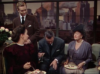 Movie still from “Rope” (1948), directed by Alfred Hitchcock – A group of people sitting around a table; Medium shot, High angle