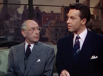 Movie still from “Rope” (1948), directed by Alfred Hitchcock – Two men in suits and ties sitting next to each other; Medium shot, Over the shoulder angle
