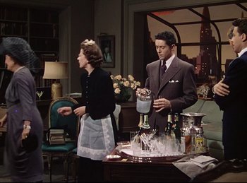 Movie still from “Rope” (1948), directed by Alfred Hitchcock – A man and a woman standing in a living room; Medium shot, Low angle