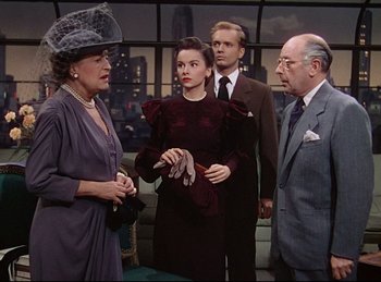 Movie still from “Rope” (1948), directed by Alfred Hitchcock – A group of people standing next to each other in a room; Medium shot, Over the shoulder angle