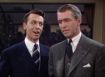 Movie still from “Rope” (1948), directed by Alfred Hitchcock – A couple of men standing next to each other; Medium shot, Low angle