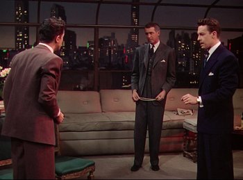 Movie still from “Rope” (1948), directed by Alfred Hitchcock – A group of men standing in front of each other; Wide shot, Over the shoulder angle