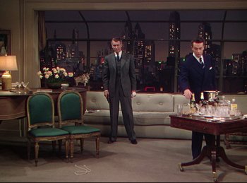 Movie still from “Rope” (1948), directed by Alfred Hitchcock – Two men in suits are standing in a living room; Wide shot, High angle
