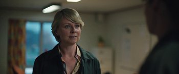 Movie still from “Rose” (2022), directed by Niels Arden Oplev – A woman with blonde hair wearing a green jacket; Close Up shot, Over the shoulder angle