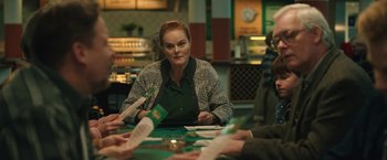 Movie still from “Rose” (2022), directed by Niels Arden Oplev – A group of people sitting around a table with papers; Medium shot, Over the shoulder angle