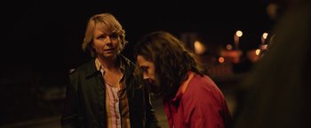 Movie still from “Rose” (2022), directed by Niels Arden Oplev – Two people standing next to each other on a street; Medium shot, Over the shoulder angle