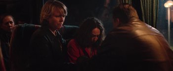 Movie still from “Rose” (2022), directed by Niels Arden Oplev – A woman in a red shirt is sitting next to another woman; Medium shot, Over the shoulder angle