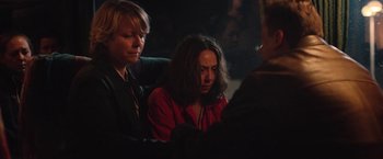 Movie still from “Rose” (2022), directed by Niels Arden Oplev – A woman sitting next to another woman in front of a crowd; Medium shot, Over the shoulder angle