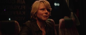 Movie still from “Rose” (2022), directed by Niels Arden Oplev – A woman with blonde hair is looking into the distance; Close Up shot, Over the shoulder angle