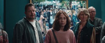 Movie still from “Rose” (2022), directed by Niels Arden Oplev – A man and a woman standing in front of a painting; Medium shot, Over the shoulder angle