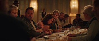 Movie still from “Rose” (2022), directed by Niels Arden Oplev – A group of people sitting at a long dinner table; Medium shot, Over the shoulder angle