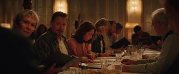 Movie still from “Rose” (2022), directed by Niels Arden Oplev – A group of people sitting at a dinner table; Medium shot, Over the shoulder angle